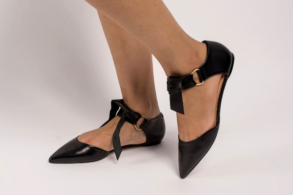 Eleora Leather Flats featuring a classic ankle strap and genuine leather upper, showcasing a stylish bow tie design.