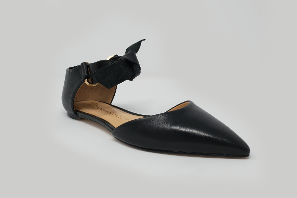 Eleora Leather Flats featuring a classic ankle strap and genuine leather upper, showcasing a stylish bow tie design.