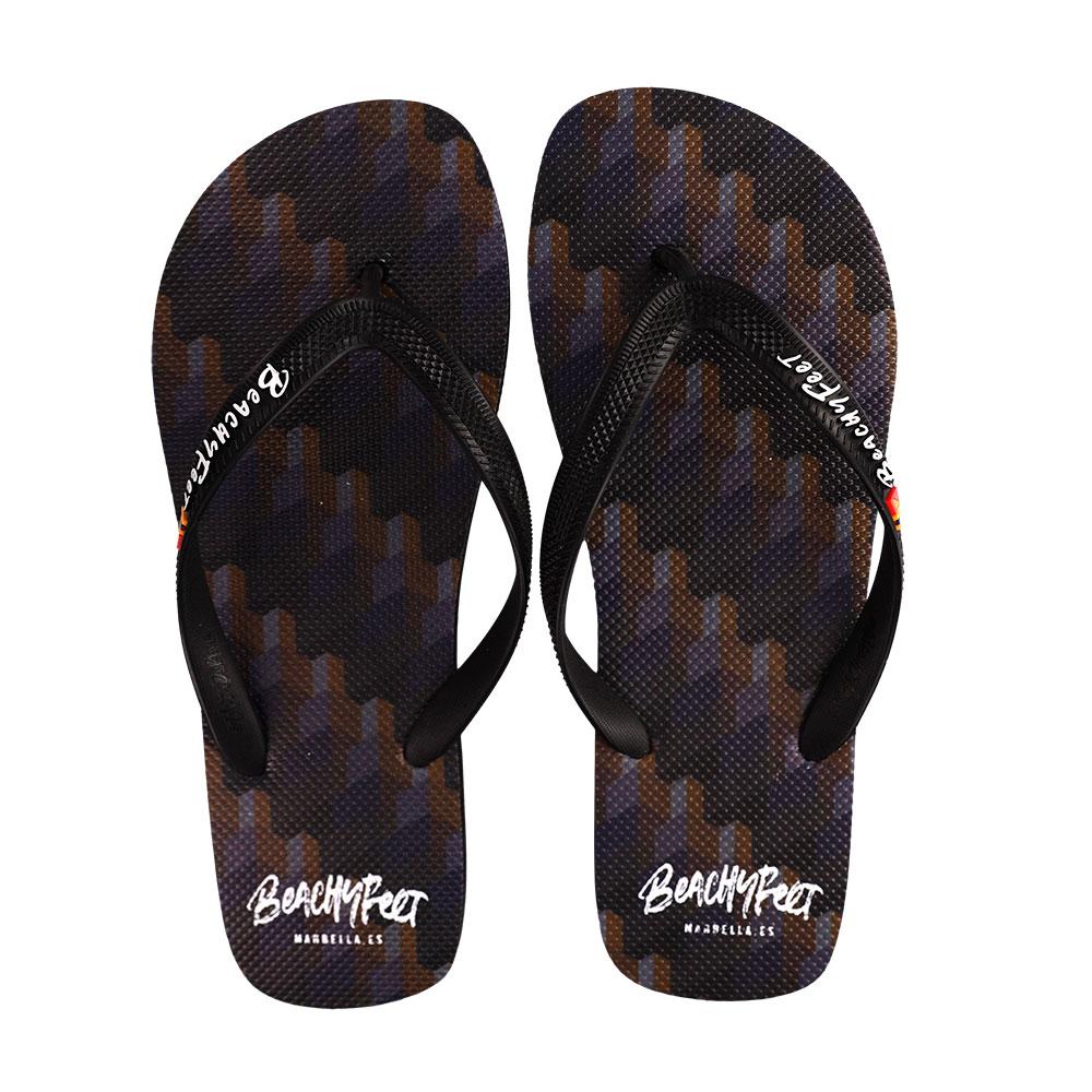 BeachyFeet® - Dame De Noche flip flops featuring a gold emblem, rugged strap, and textured footbed, perfect for summer wear.