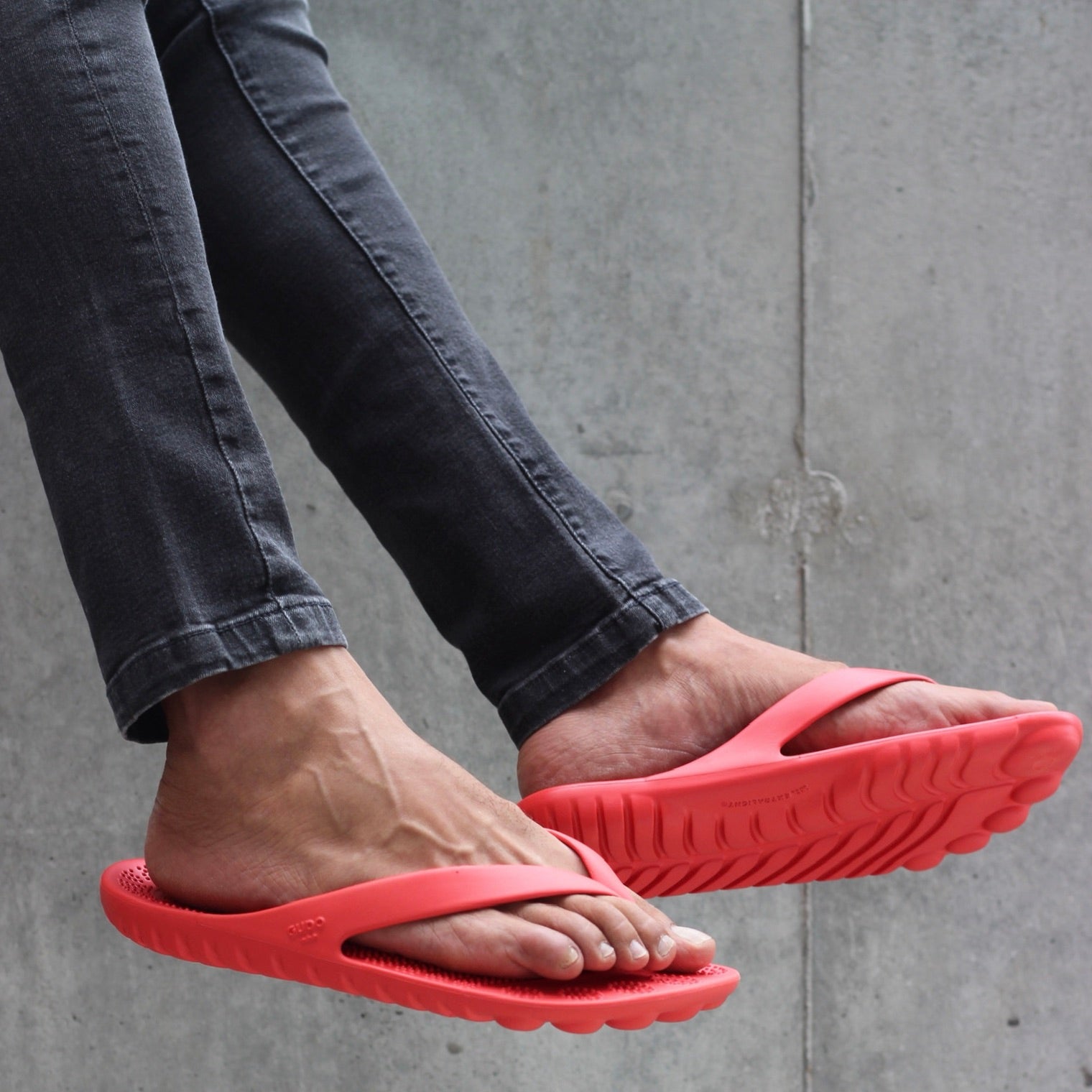 A pair of vibrant Fire Red Flip-Flops by GUDO, showcasing a minimalist design and unique sole pattern, perfect for beach and casual wear.