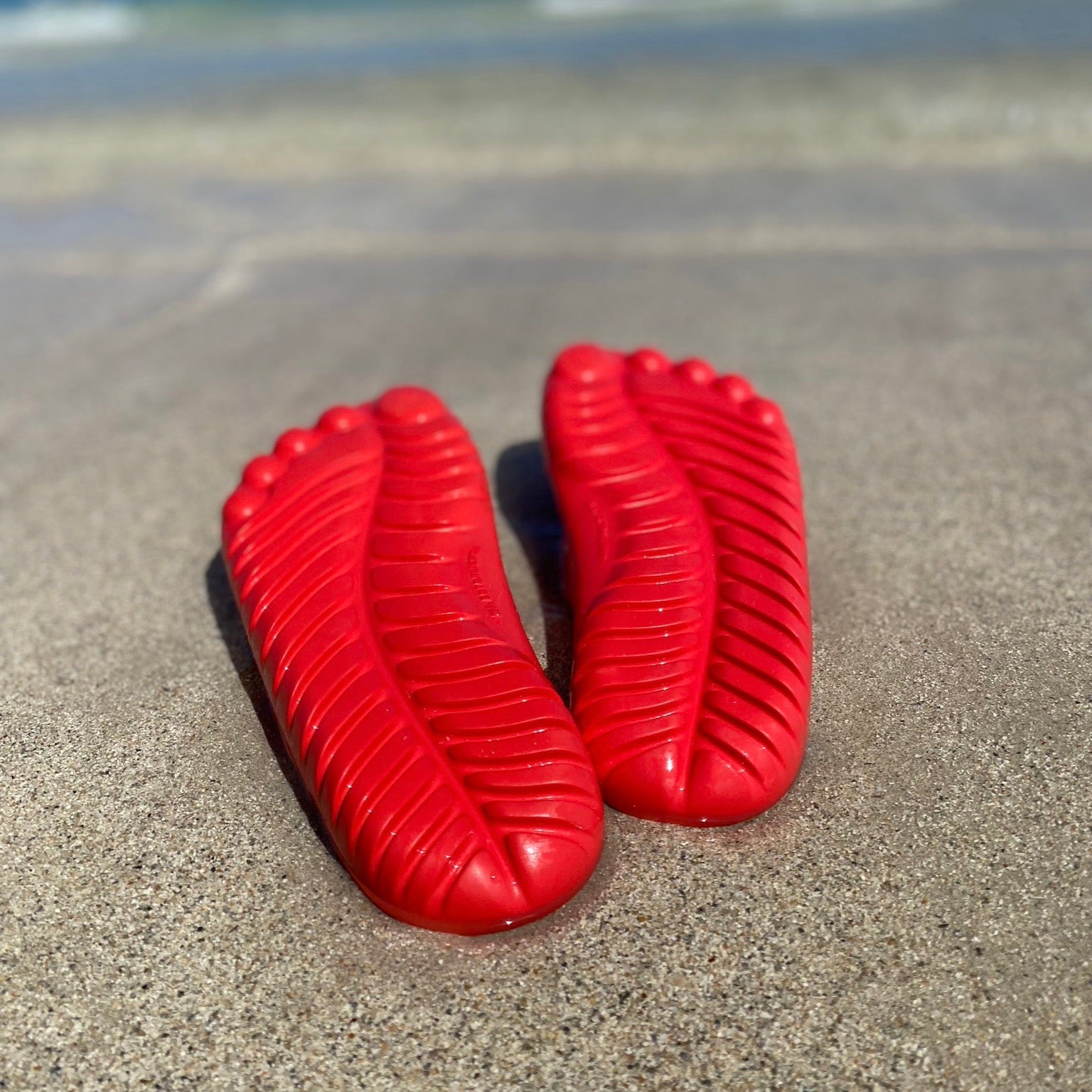 A pair of vibrant Fire Red Flip-Flops by GUDO, showcasing a minimalist design and unique sole pattern, perfect for beach and casual wear.