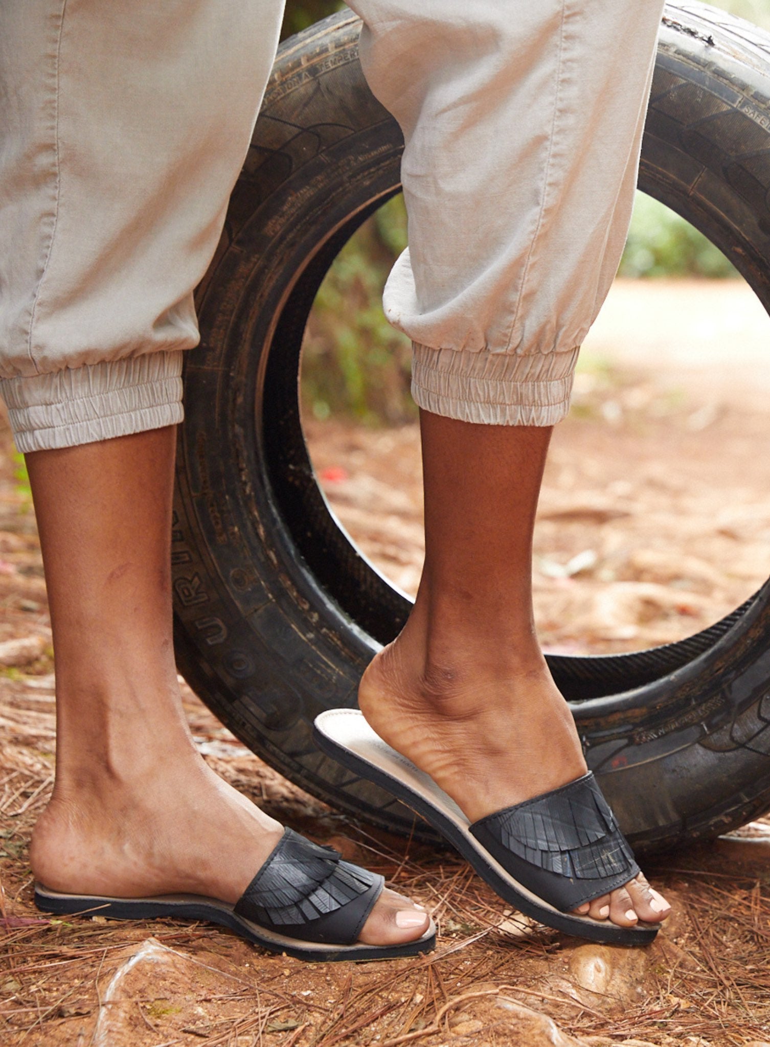 Stylish black Fringe Slide Sandal with edgy fringe detail, made from genuine leather and up-cycled materials.