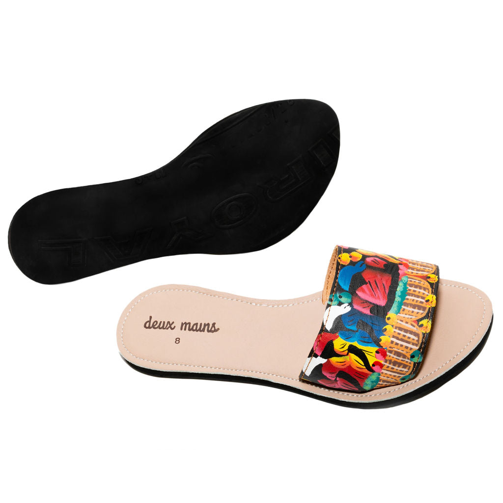 A pair of hand painted slide sandals featuring vibrant colors and unique designs, crafted from genuine leather with a repurposed tire sole.