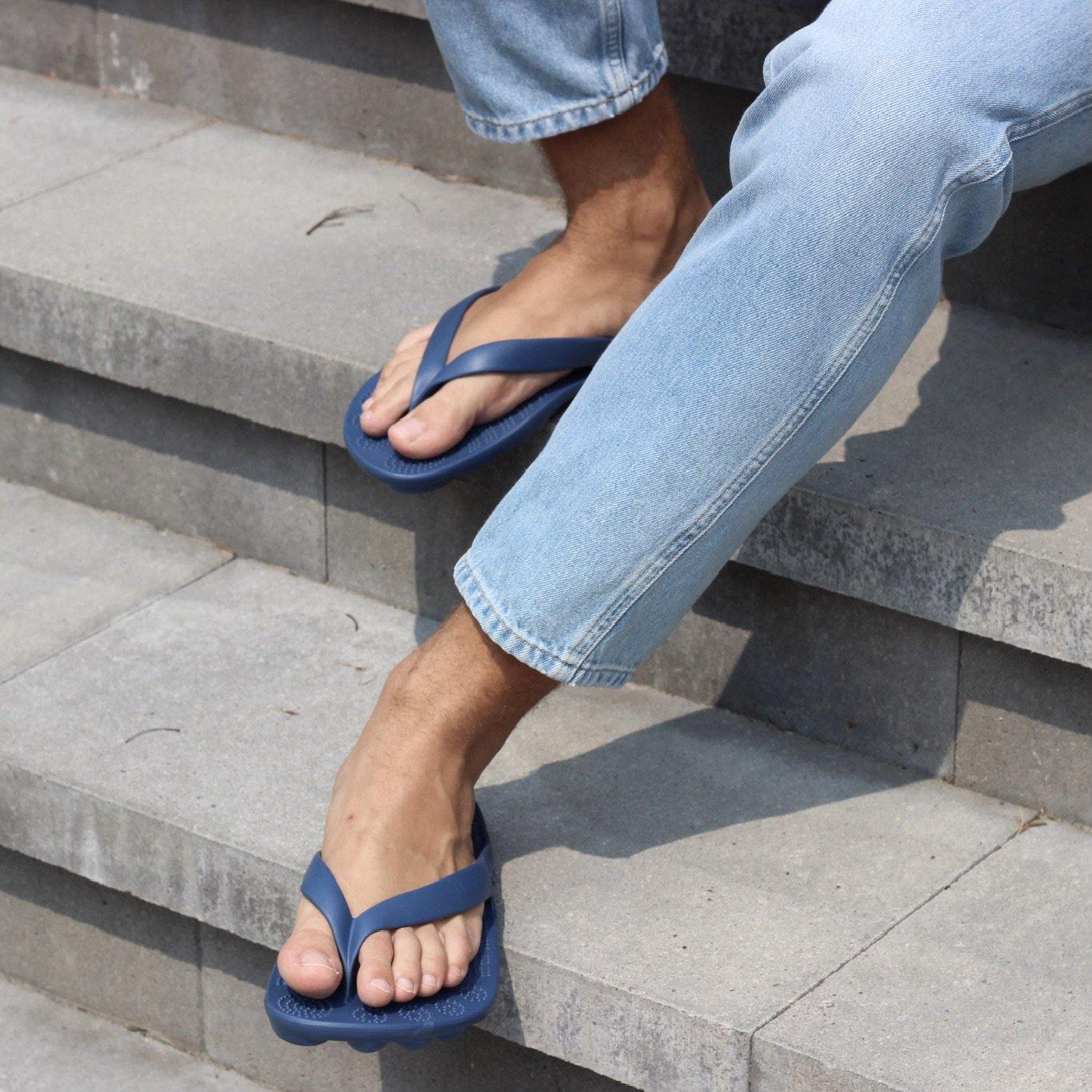 GUDO Navy Blue Flip-Flops displayed with a waterproof mini drybag, showcasing their stylish design and eco-friendly materials.