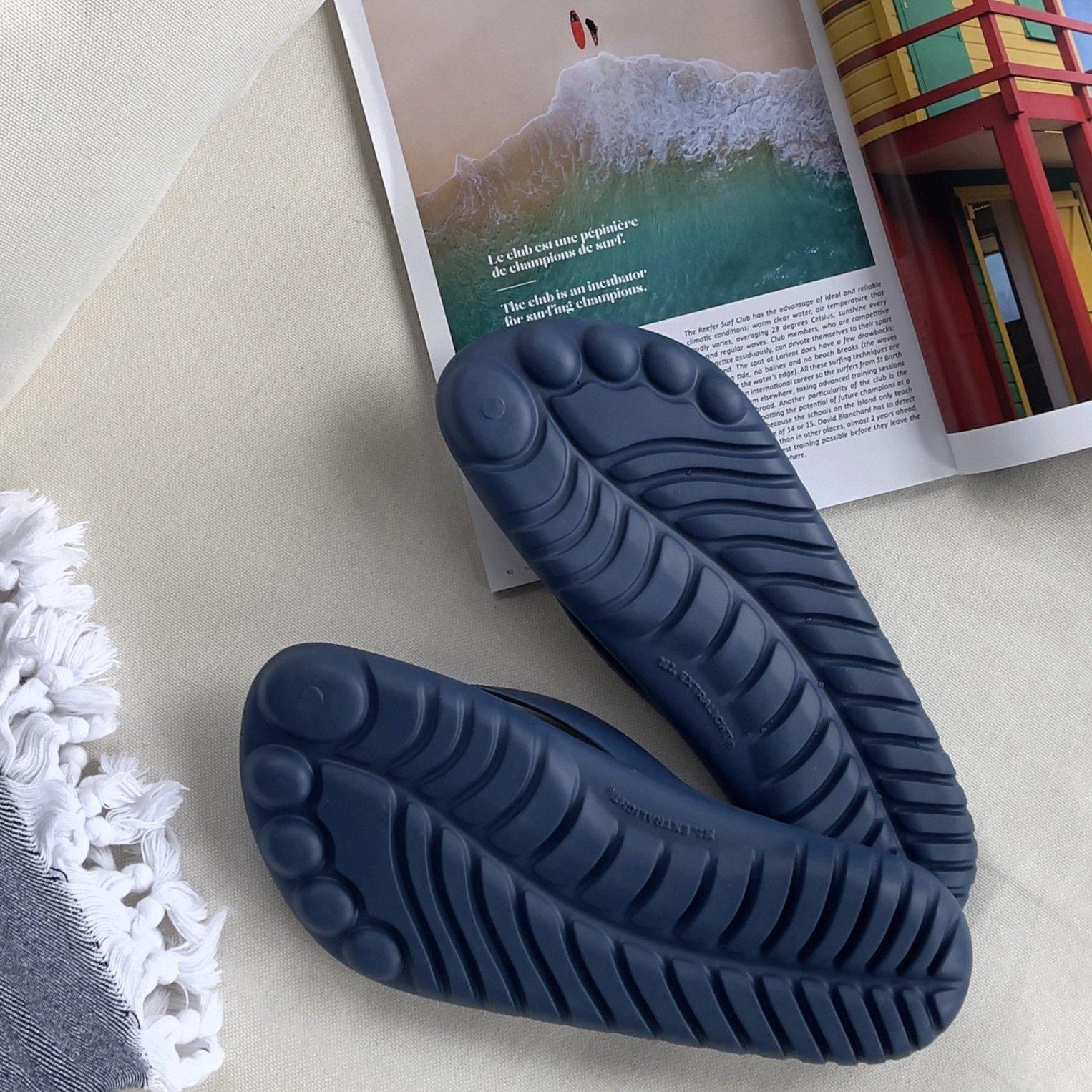 GUDO Navy Blue Flip-Flops displayed with a waterproof mini drybag, showcasing their stylish design and eco-friendly materials.