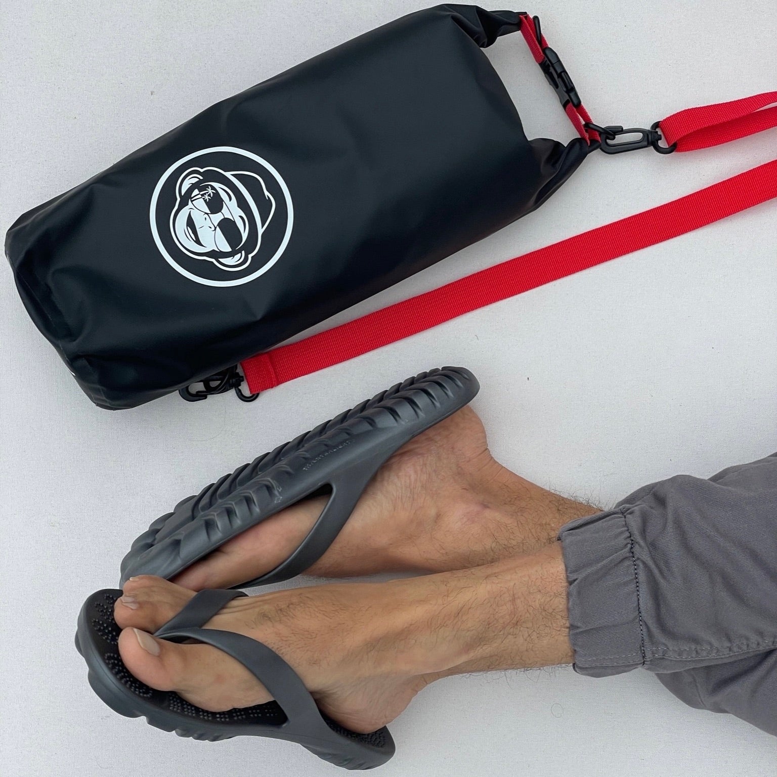 GUDO Night Platinum Flip-Flops displayed with a waterproof mini drybag, showcasing their minimalist design and eco-friendly materials.