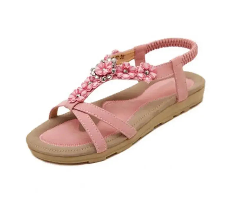 A pair of stylish pink flower sandals for women, featuring a flat heel and adjustable ankle strap, perfect for casual wear.