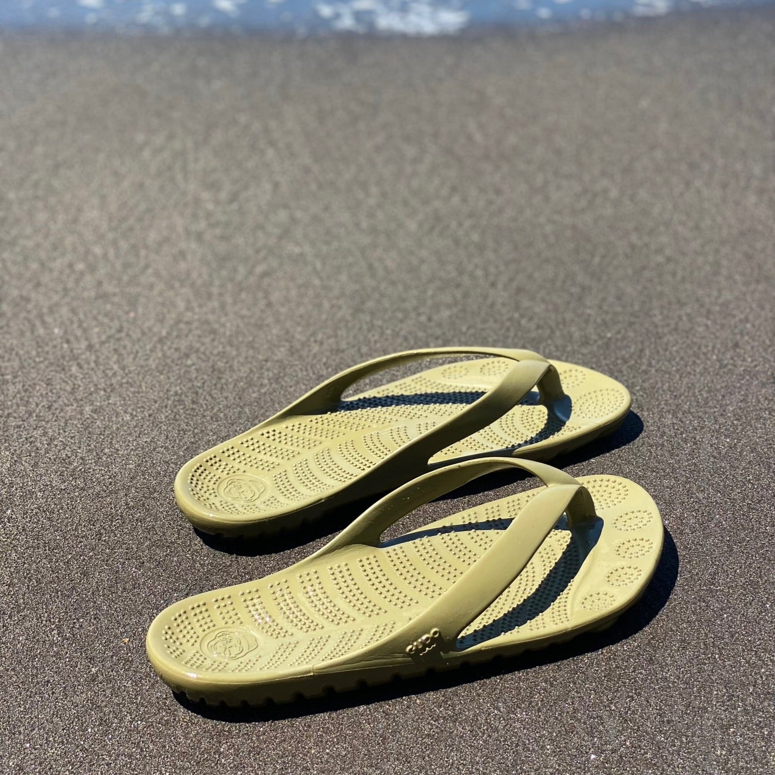 Seaweed Green Flip-Flops with a waterproof mini drybag, showcasing a minimalist design and eco-friendly materials.