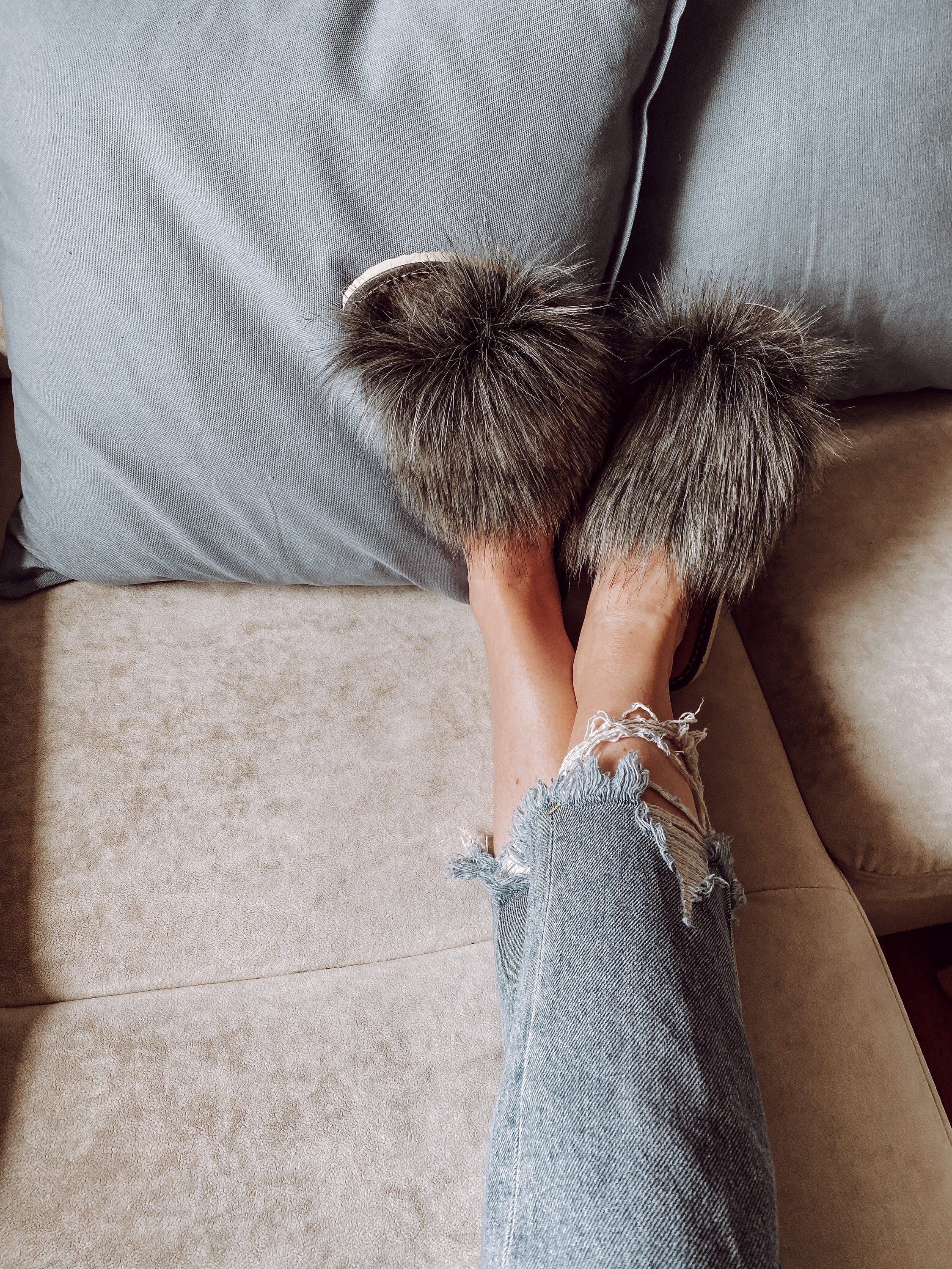 Cozy faux fur grey slippers with a cushioned insole and foam bottom, perfect for home wear.