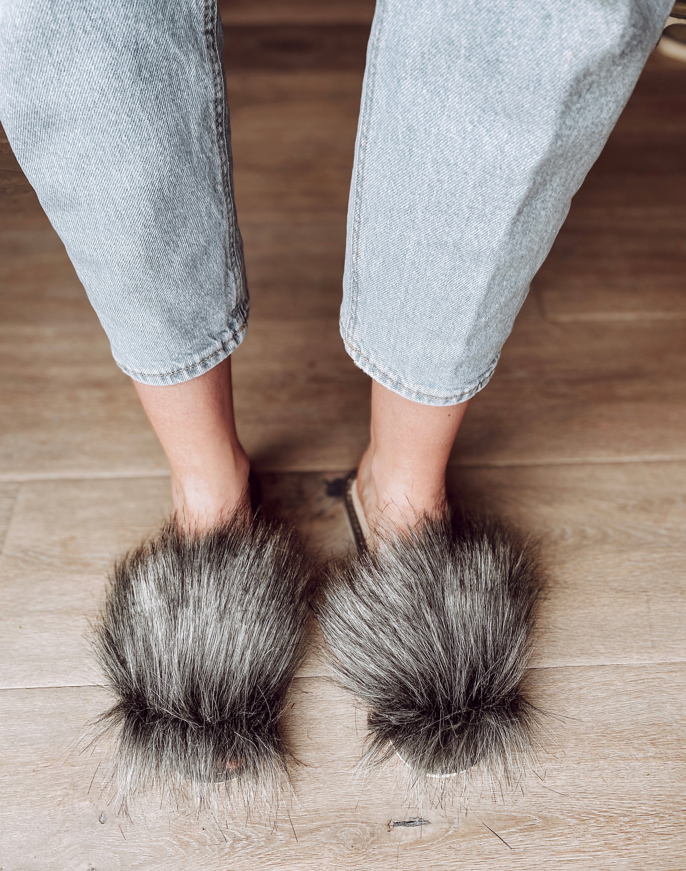 Cozy faux fur grey slippers with a cushioned insole and foam bottom, perfect for home wear.