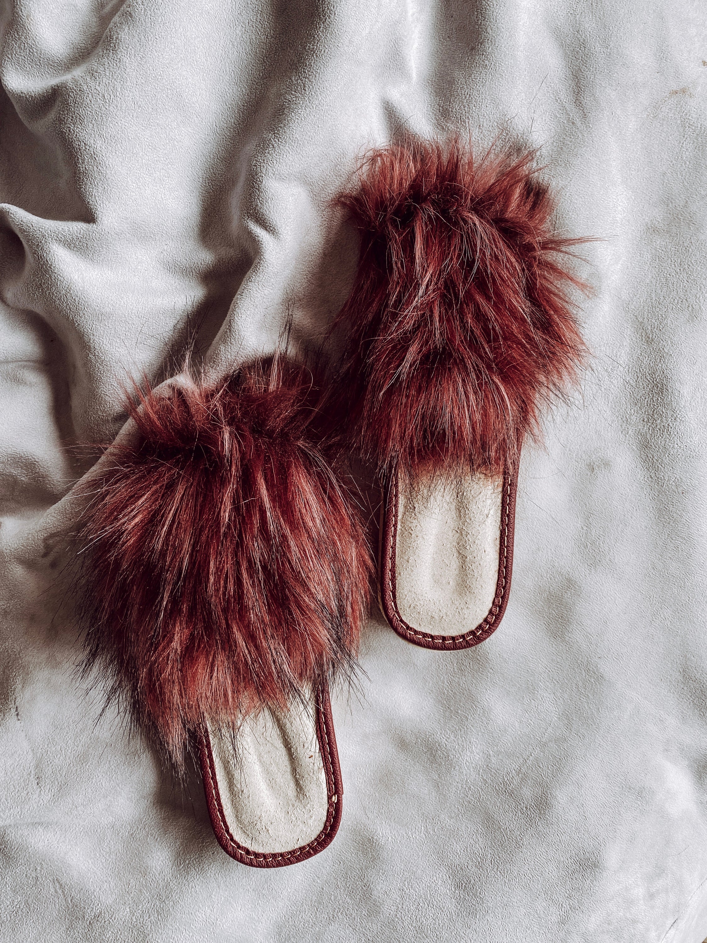 Cozy faux fur pink slippers with cushioned insole and foam bottom, perfect for home wear.