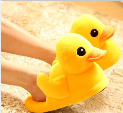 A pair of cute yellow duck slippers designed for women, featuring soft plush material and a whimsical design, perfect for indoor winter wear.