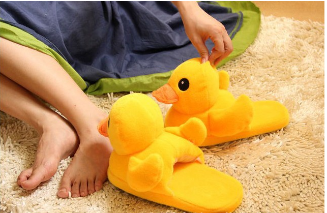 A pair of cute yellow duck slippers designed for women, featuring soft plush material and a whimsical design, perfect for indoor winter wear.