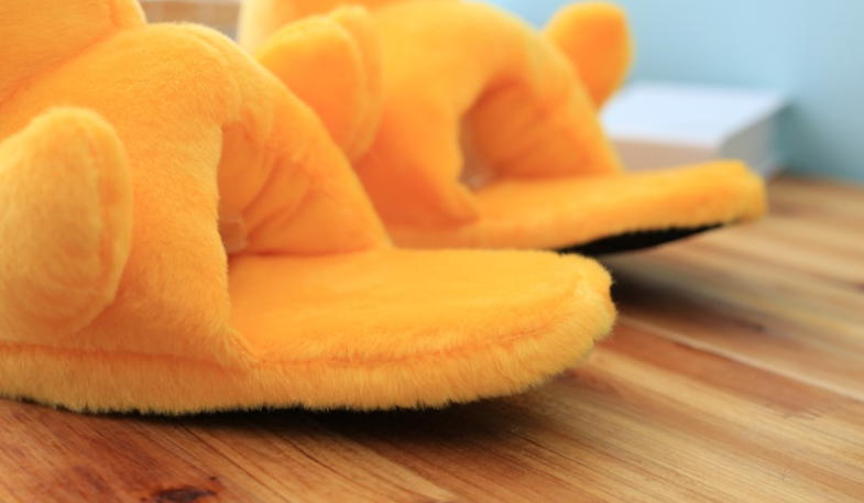 A pair of cute yellow duck slippers designed for women, featuring soft plush material and a whimsical design, perfect for indoor winter wear.