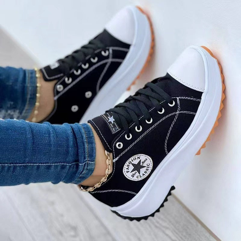 Flat lace-up sneakers made of canvas, featuring a stylish design suitable for casual and sporty occasions.