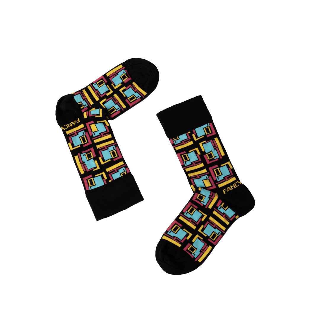 A pair of stylish black and green geometric socks displayed together, showcasing their unique design and vibrant colors.