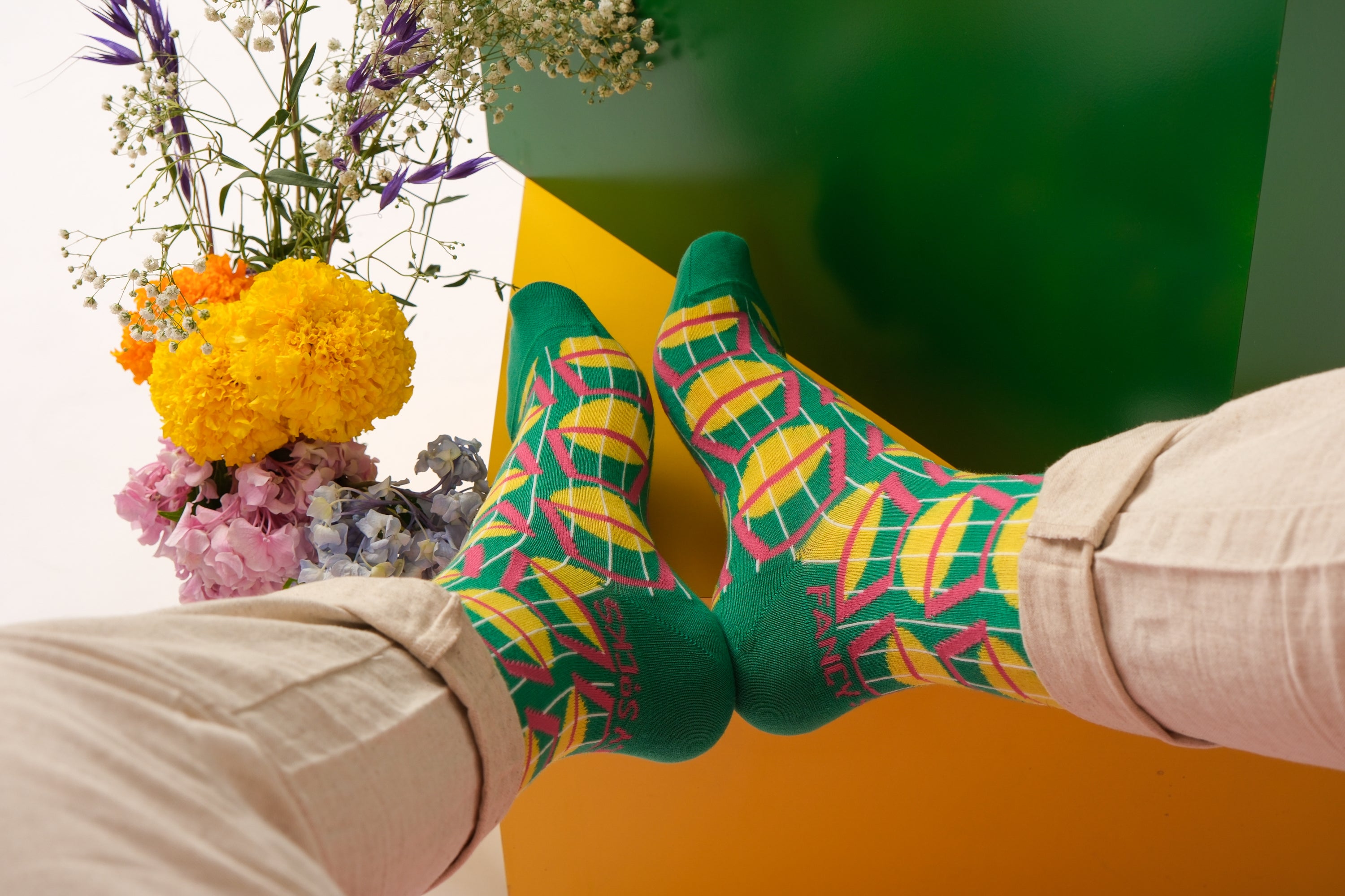 A pair of stylish black and green geometric socks displayed together, showcasing their unique design and vibrant colors.