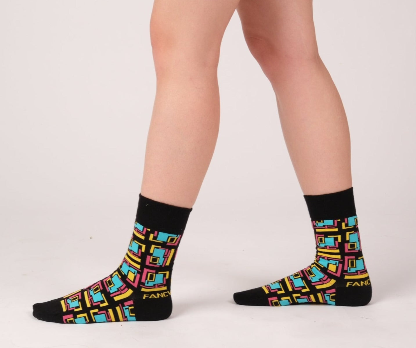 A pair of stylish black and green geometric socks displayed together, showcasing their unique design and vibrant colors.