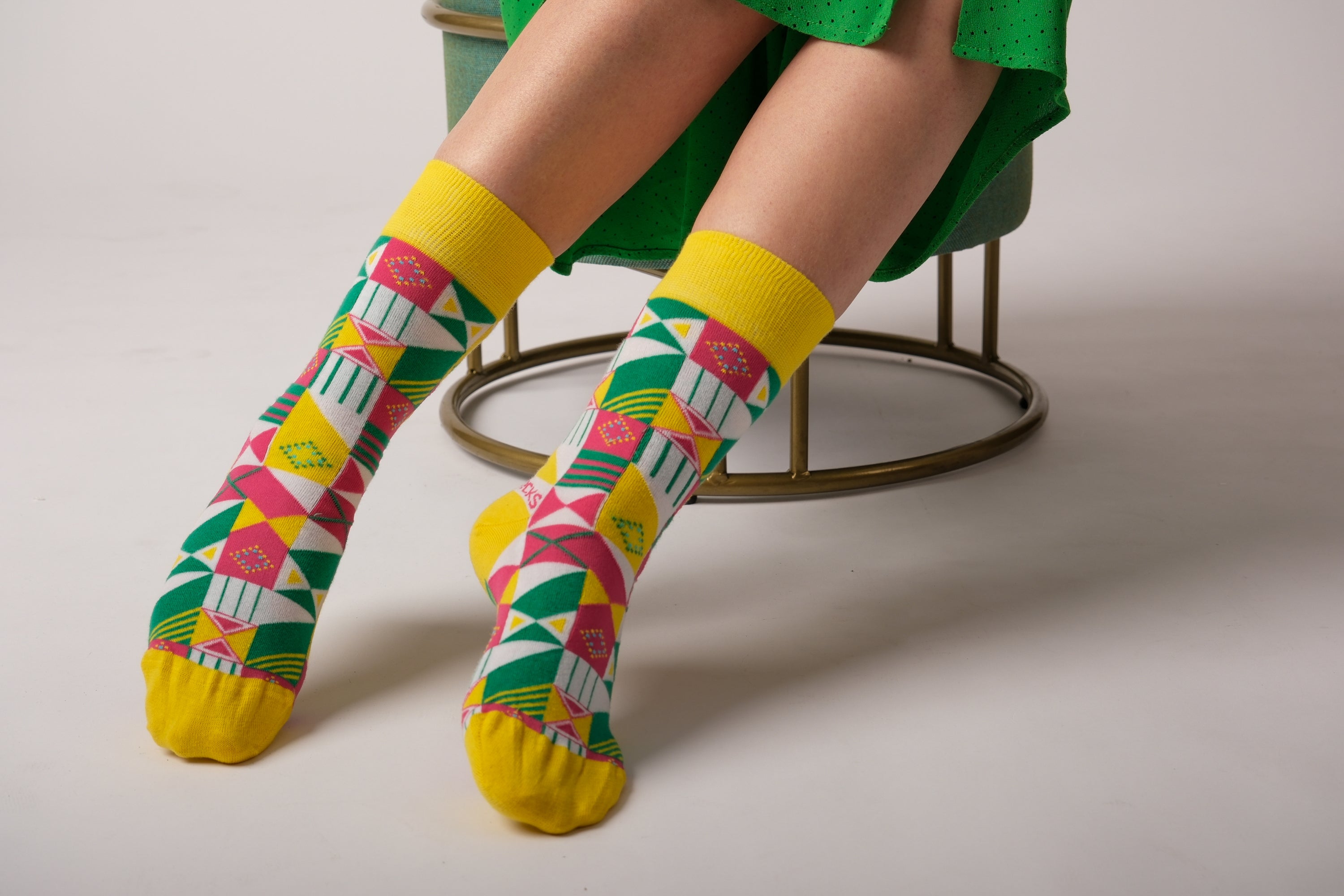 A pair of vibrant yellow and green geometric socks displayed together, showcasing their unique patterns and soft texture.