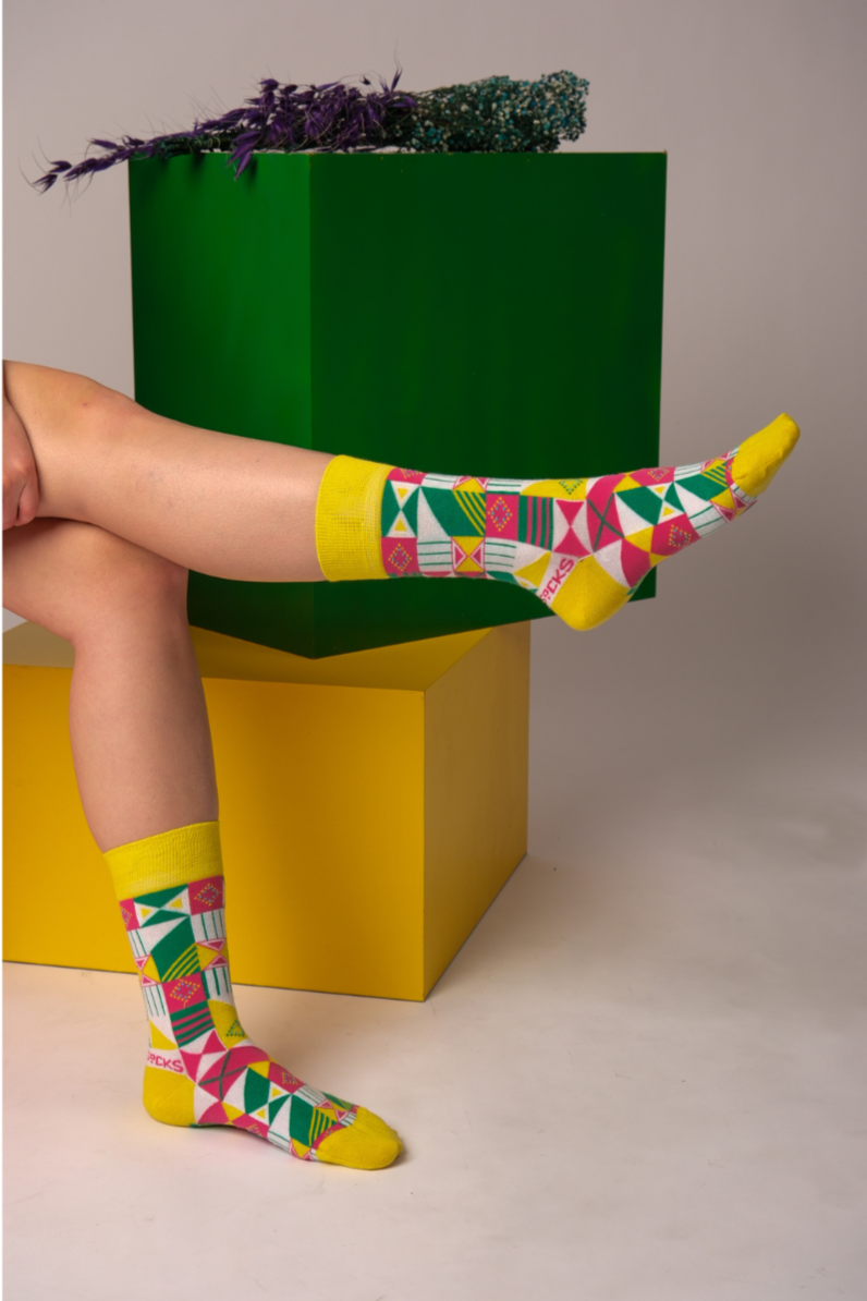 A pair of yellow and white geometric socks displayed together, showcasing their vibrant colors and stylish pattern.