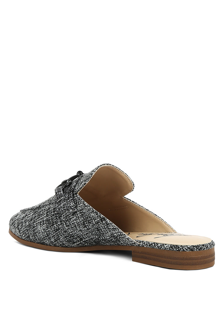 Stylish Akua Horsebit Embellished Mules featuring a classic horsebit design, low heel, and textured canvas upper.