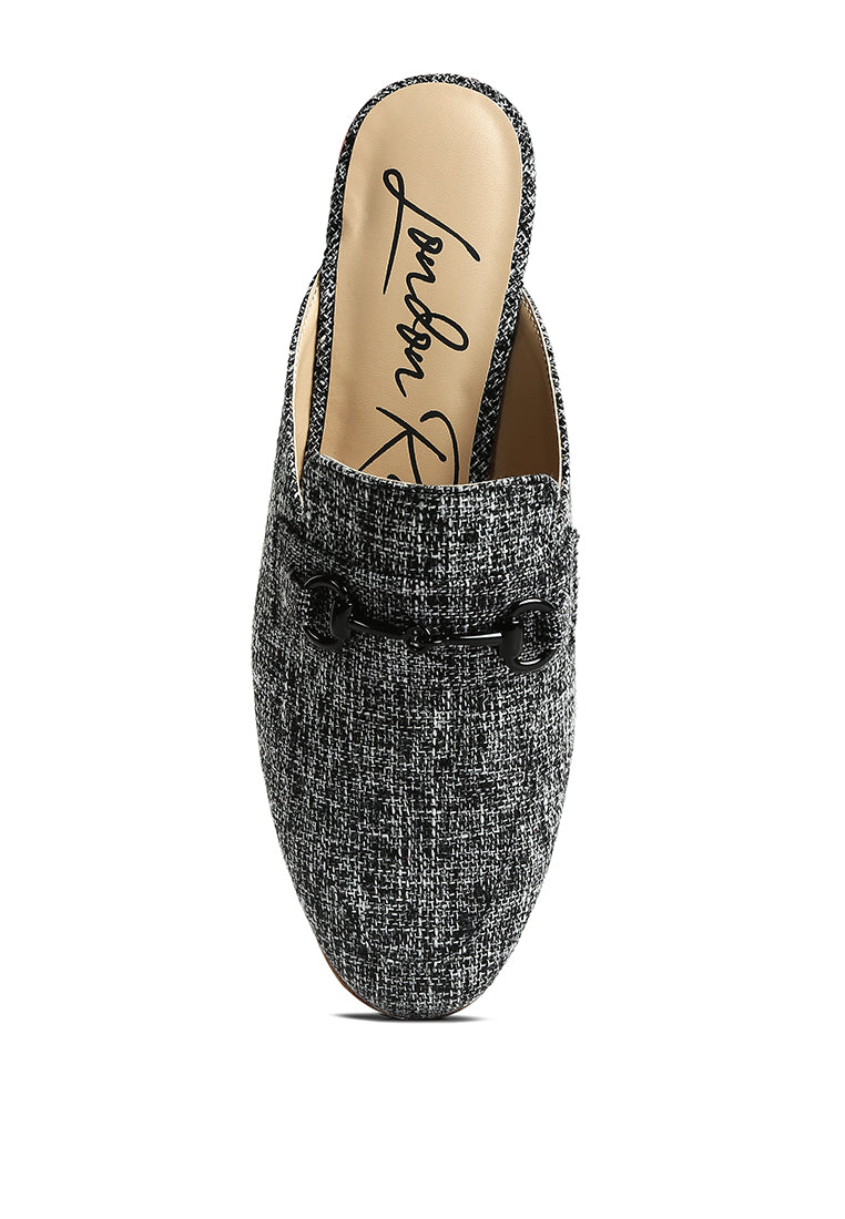 Stylish Akua Horsebit Embellished Mules featuring a classic horsebit design, low heel, and textured canvas upper.