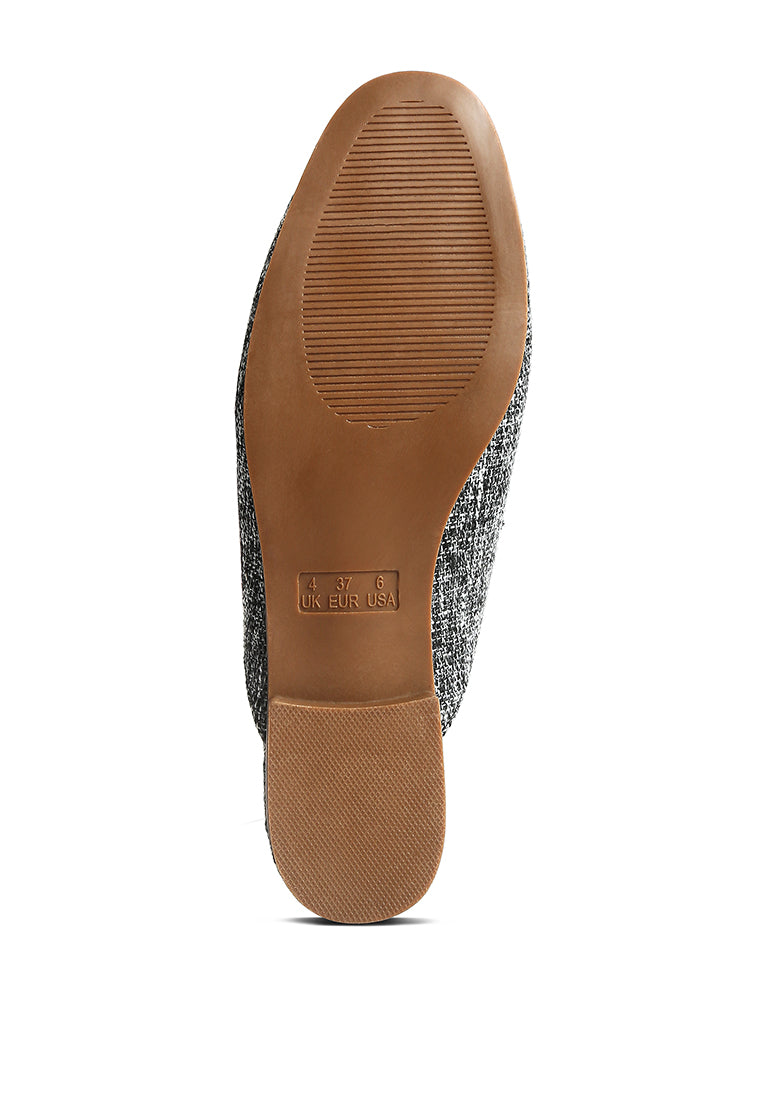 Stylish Akua Horsebit Embellished Mules featuring a classic horsebit design, low heel, and textured canvas upper.