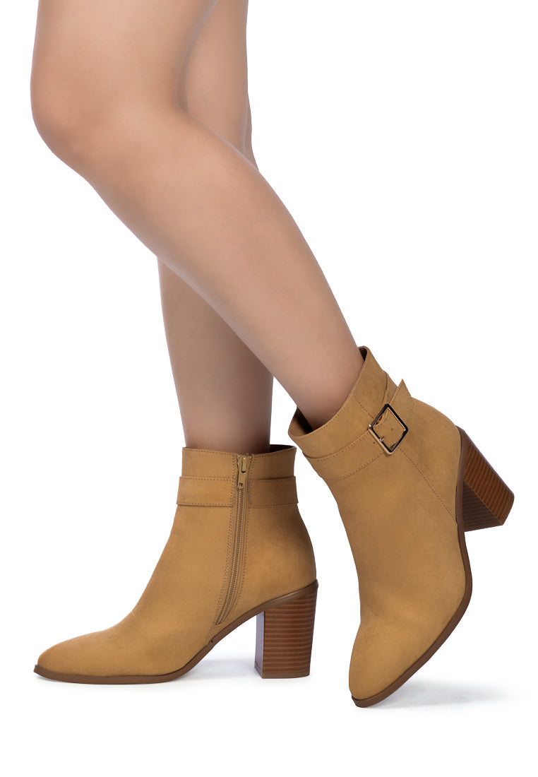 Stylish taupe faux suede ankle boots with pointed toe and buckle detail, featuring a side zipper and block heel.