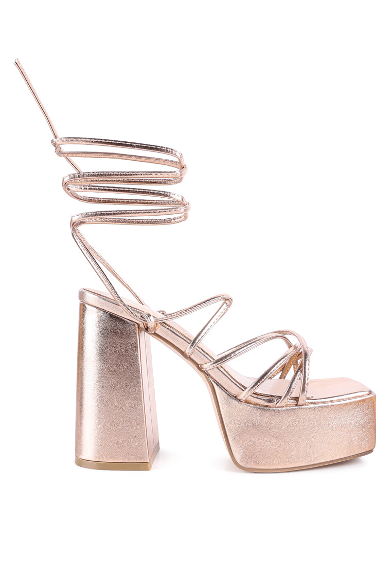 Anvil Metallic Block Heeled Lace Up Sandals featuring a shiny metallic faux leather upper, open square toe, and trendy lace-up design.