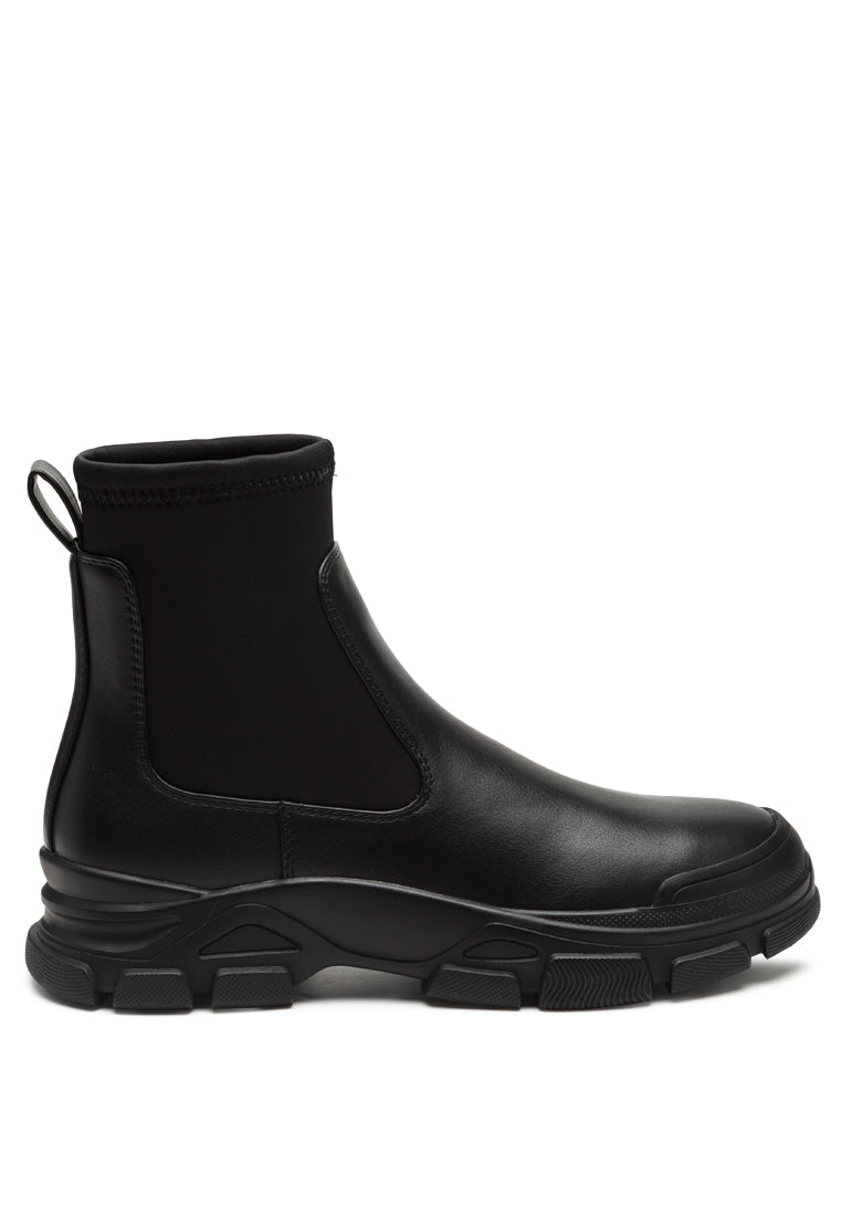 Stylish black Chelsea ankle boots with lug sole and elastic gussets, perfect for any outfit.