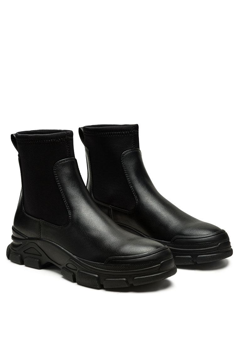 Stylish black Chelsea ankle boots with lug sole and elastic gussets, perfect for any outfit.