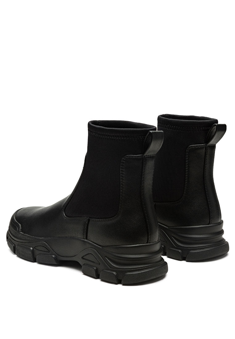 Stylish black Chelsea ankle boots with lug sole and elastic gussets, perfect for any outfit.