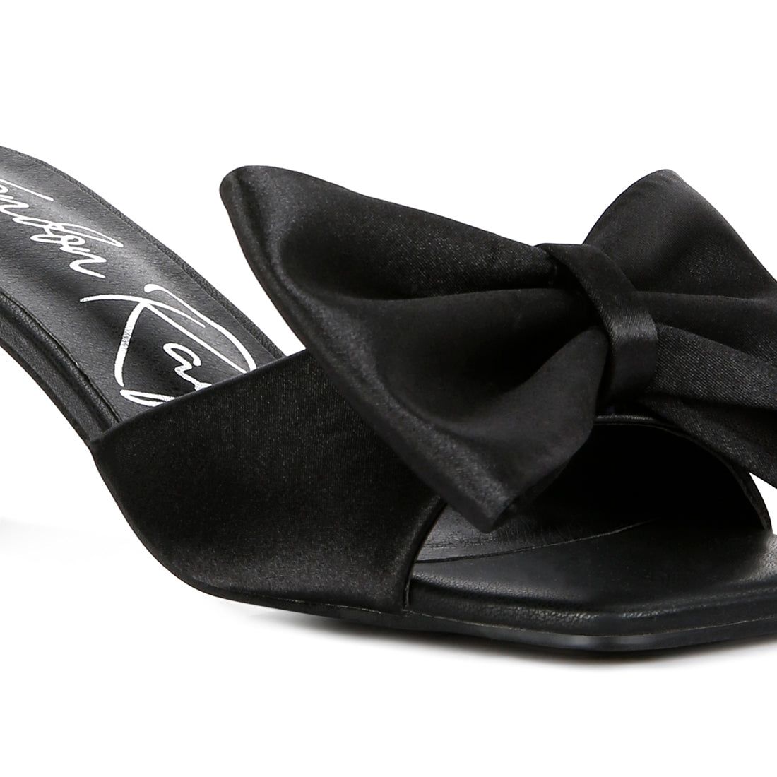 A pair of elegant black satin kitten heel sandals featuring a large bow on top, perfect for stylish occasions.