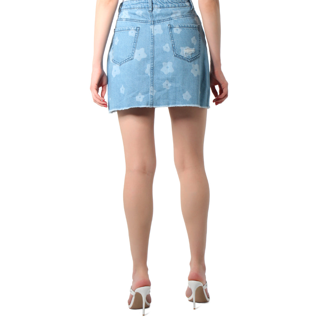 Blue flower print ripped jeans mini skirt with frayed hem and pockets, showcasing a stylish and flirty design.