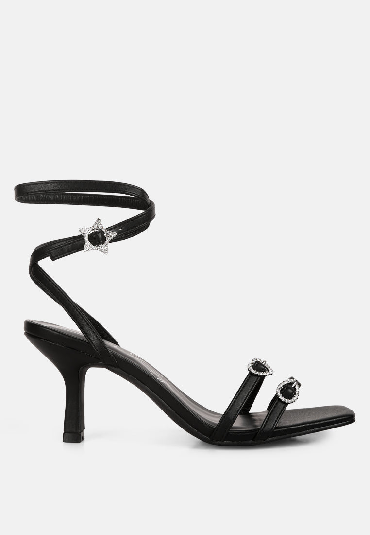 A pair of elegant black buckle high heel sandals featuring a stiletto heel and open square toe design.