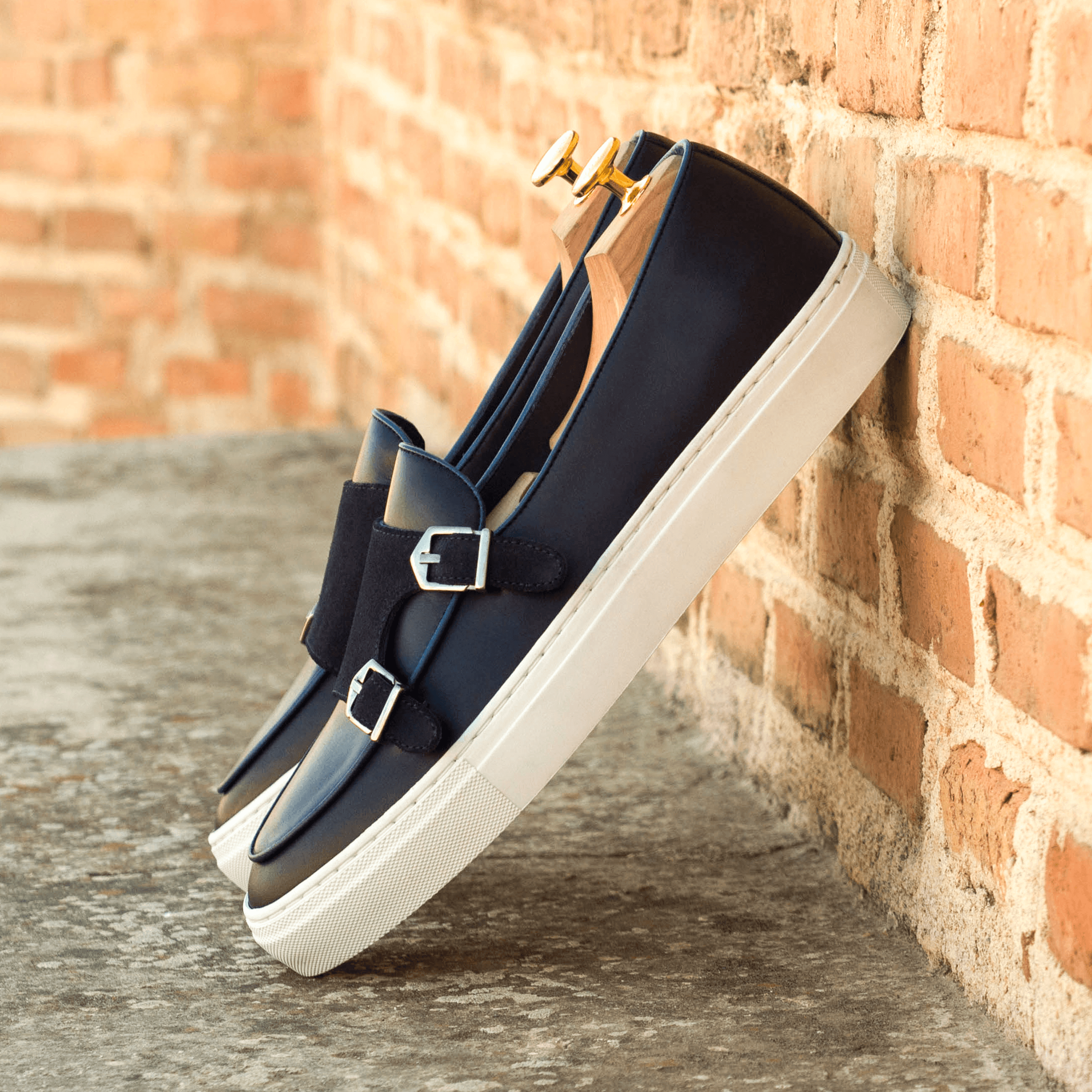 Celsus Monk Sneaker II featuring a double monk strap design with a white and black cupsole, crafted from premium navy and black leather materials.