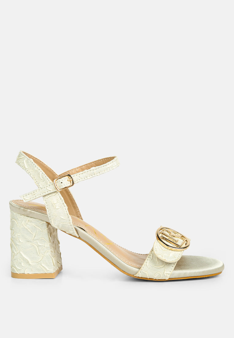 Chaplet Textured Block Heel Sandals featuring a satin upper, block heel, and pin buckle closure, perfect for stylish comfort.