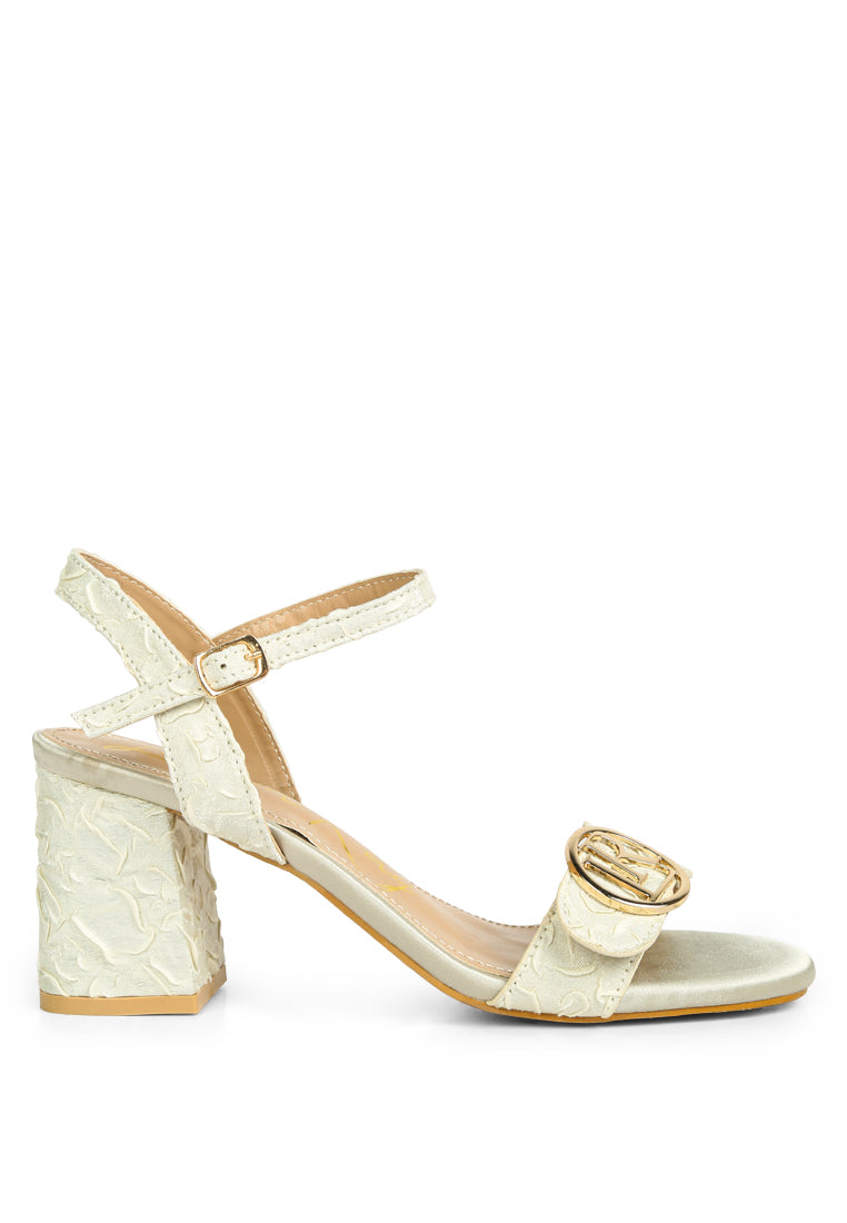 Chaplet Textured Block Heel Sandals featuring a satin upper, block heel, and pin buckle closure, perfect for stylish comfort.