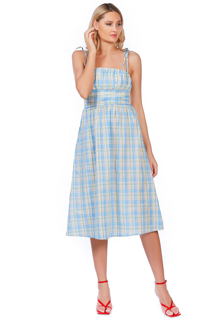 A stylish checkered midi slip dress with tie-up straps and a wrapped waist, made from 100% cotton, perfect for casual outings.