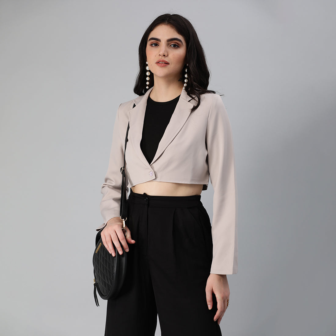 A stylish cropped tailored blazer featuring lapels and button detailing, made from a soft polyester-spandex blend.