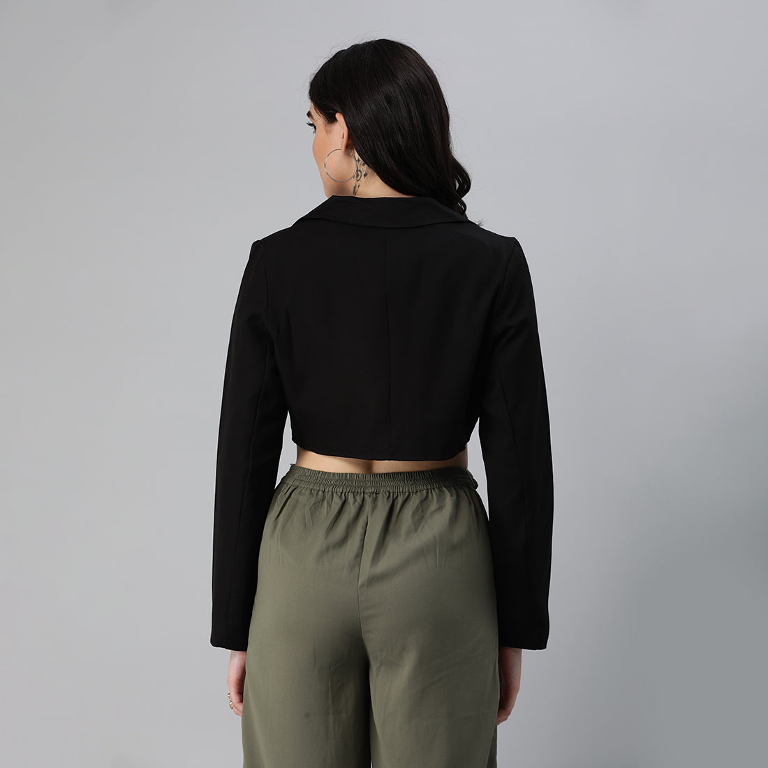 A stylish cropped tailored blazer featuring lapels and button detailing, made from a soft polyester-spandex blend.