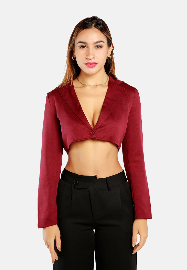 A stylish cropped tailored blazer featuring lapels and button detailing, made from a soft polyester-spandex blend.