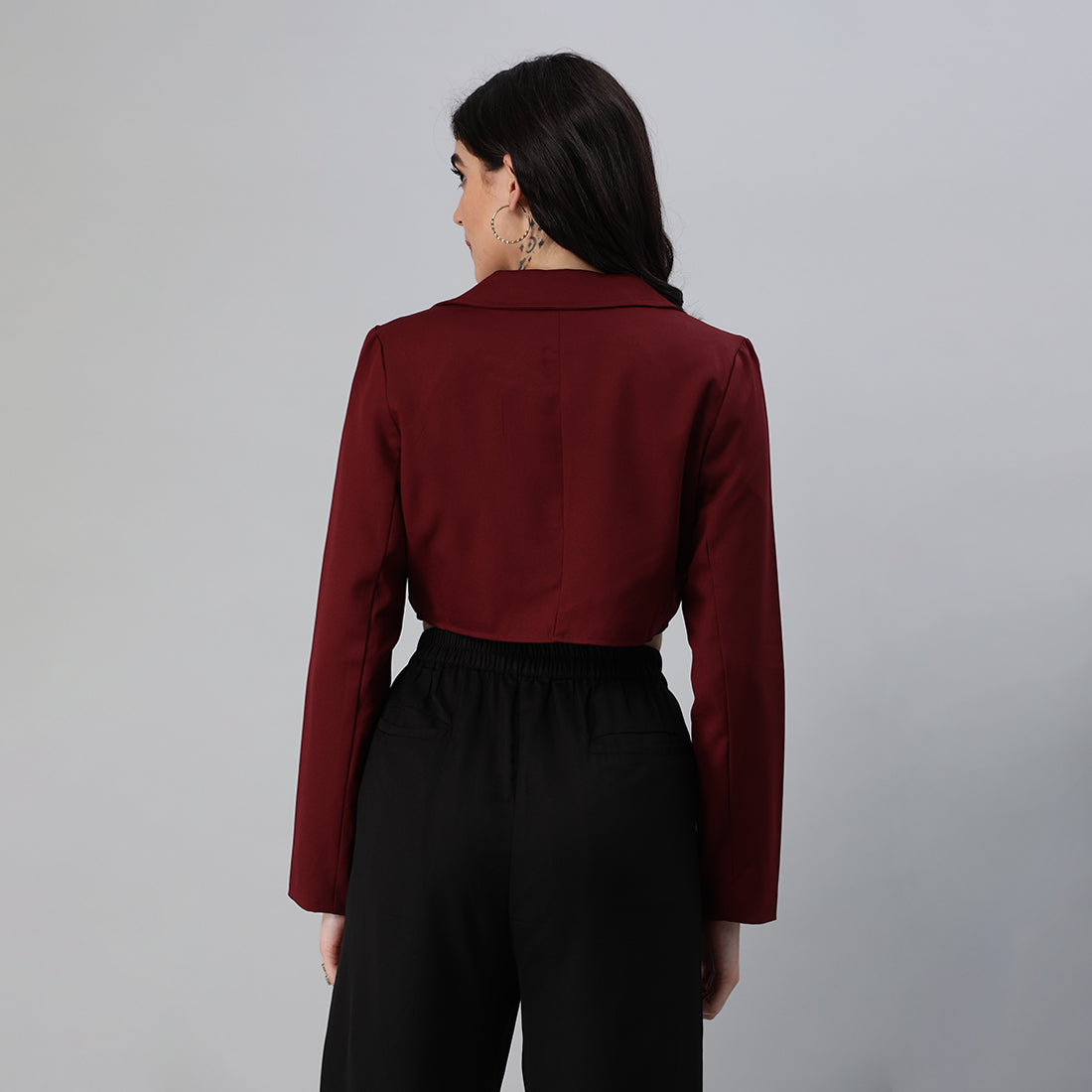 A stylish cropped tailored blazer featuring lapels and button detailing, made from a soft polyester-spandex blend.