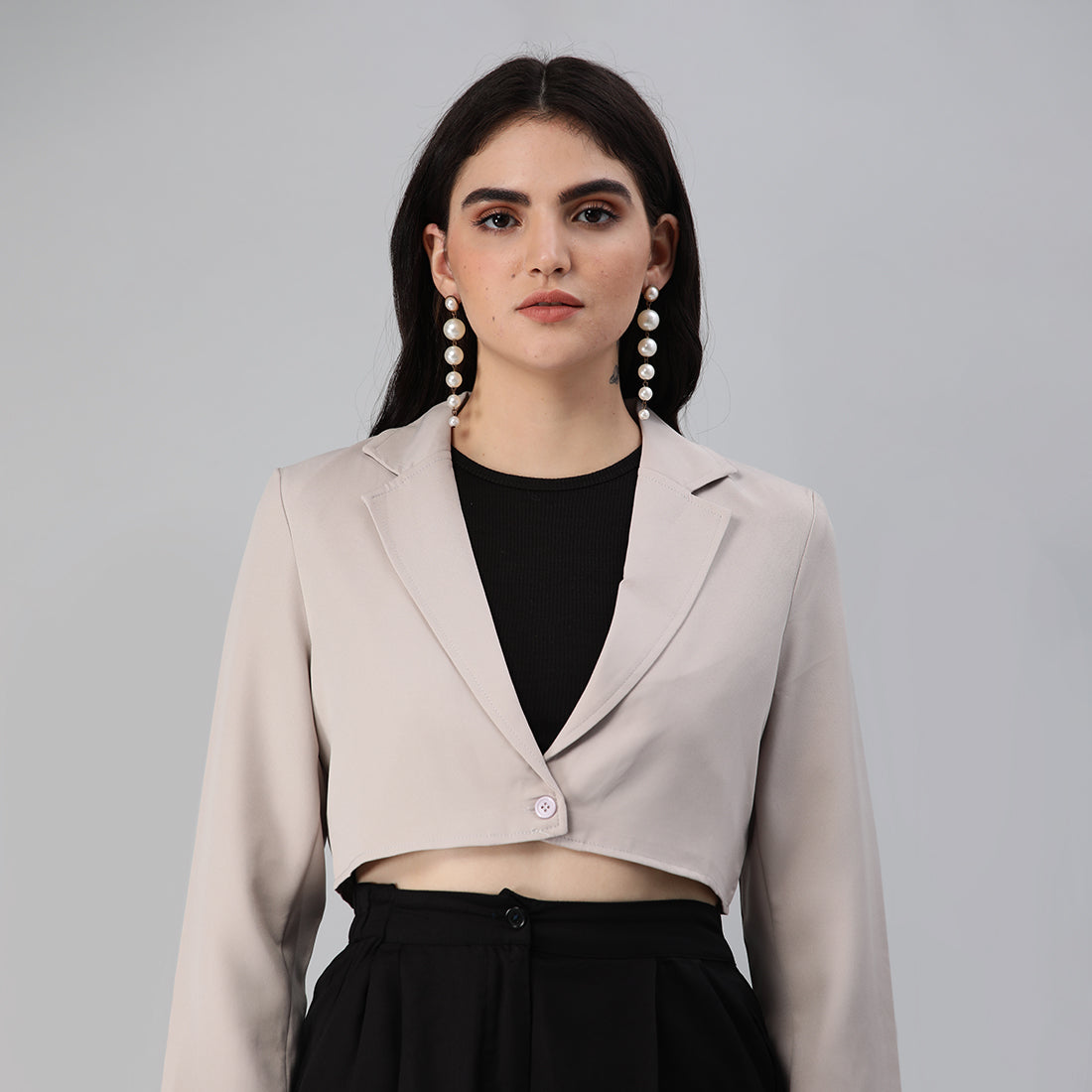 A stylish cropped tailored blazer featuring lapels and button detailing, made from a soft polyester-spandex blend.