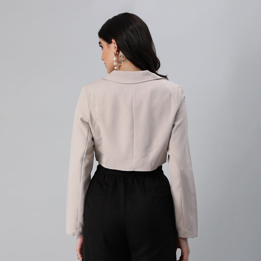 A stylish cropped tailored blazer featuring lapels and button detailing, made from a soft polyester-spandex blend.