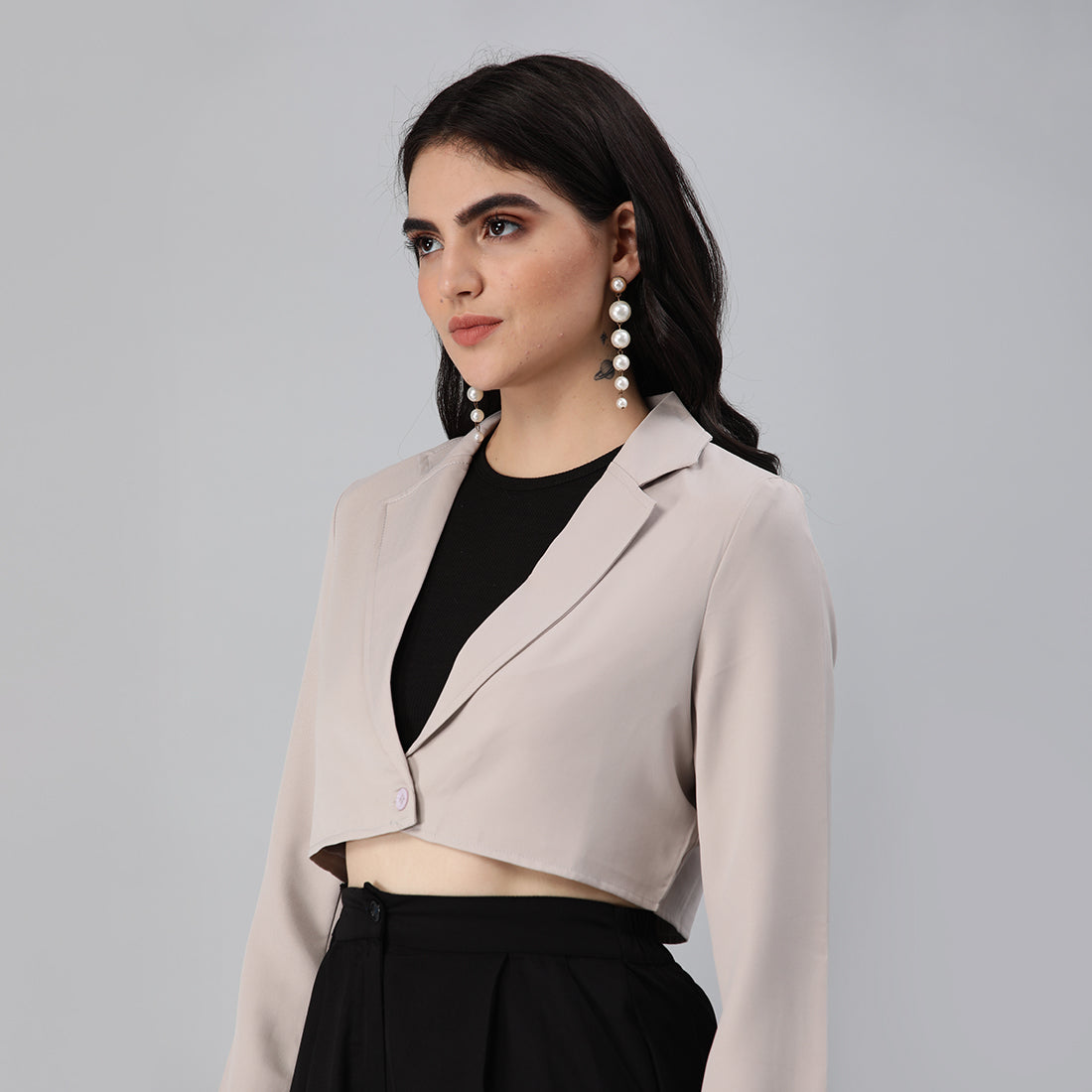 A stylish cropped tailored blazer featuring lapels and button detailing, made from a soft polyester-spandex blend.