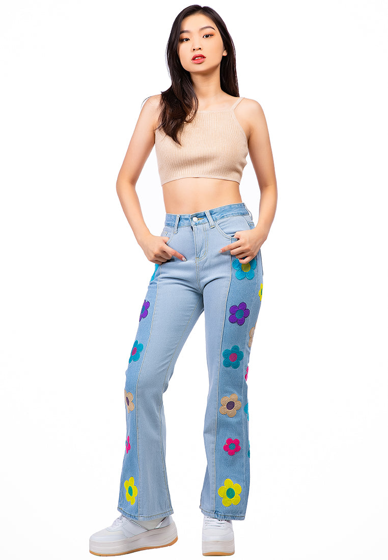 A pair of women's boot-cut jeans featuring embroidered daisy patterns on a washed denim fabric, showcasing a relaxed fit and multiple pockets.