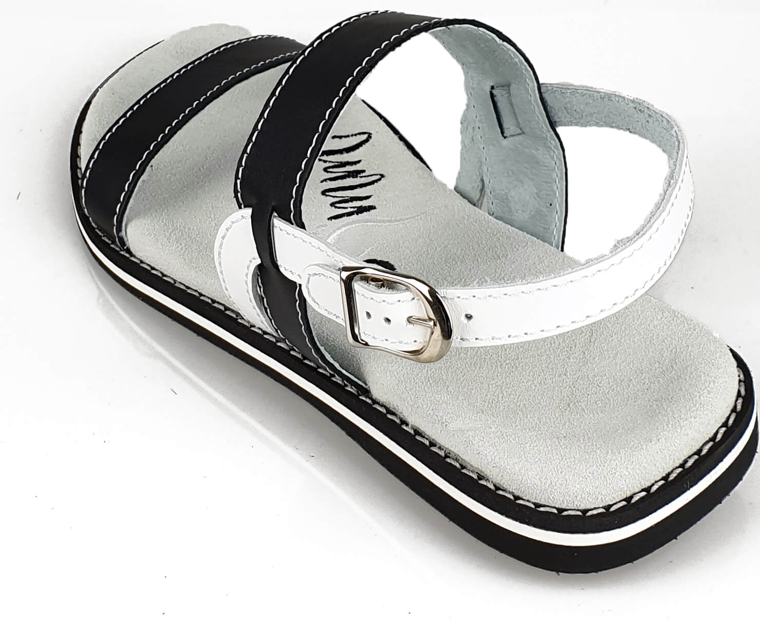 Stylish black and white leather flip-flops with adjustable strap and anatomical footbed, perfect for summer wear.