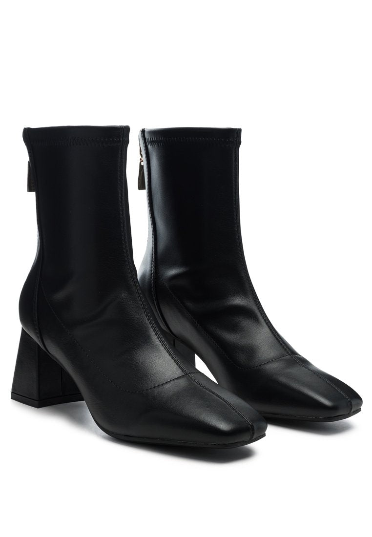 Hera Runaway Classic Ankle Boots featuring block heel and back zipper, made from faux leather.