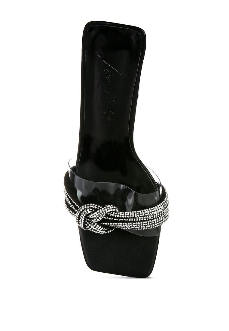 Hiorda Rhinestone Knotted Spool Heel Sandals featuring clear faux leather, rhinestone embellishments, and a stylish spool heel.